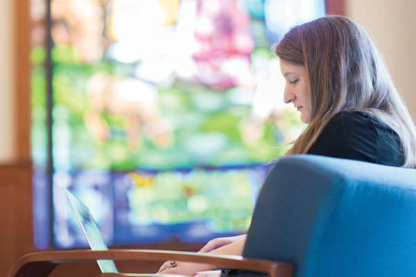 A student studies in the Brian and Paqui Kelly Atrium of the Tsotsis Family Academic Center.